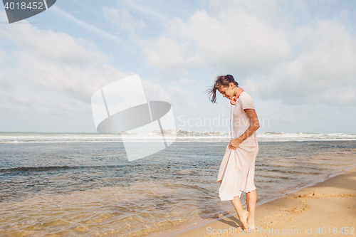 Image of Woman walking on the beach