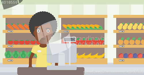 Image of Cashier standing at the checkout in supermarket.