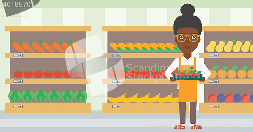 Image of Supermarket worker with box full of apples.