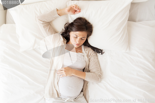 Image of happy pregnant woman sleeping in bed at home