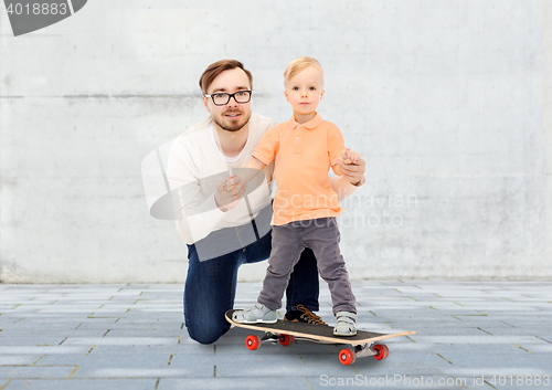 Image of happy father and little son on skateboard