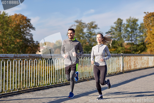 Image of happy couple running outdoors