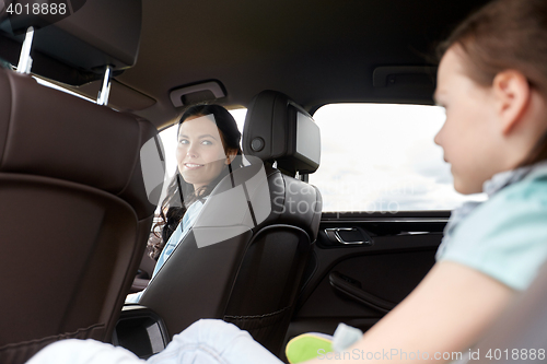 Image of happy family with little child driving in car