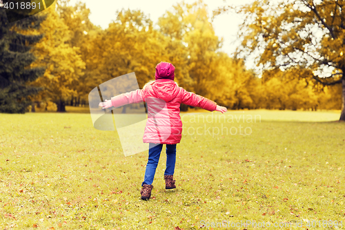 Image of happy little girl having fun in autumn park