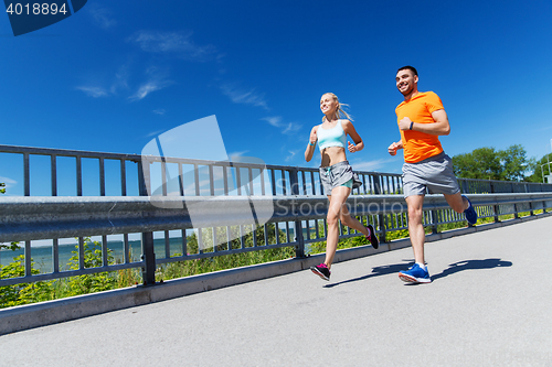 Image of smiling couple running at summer seaside