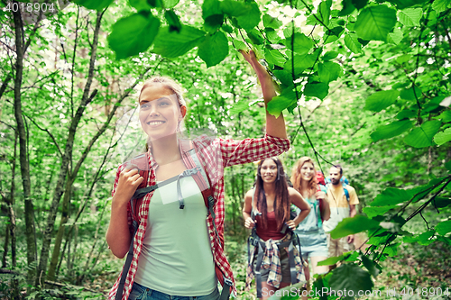 Image of group of smiling friends with backpacks hiking