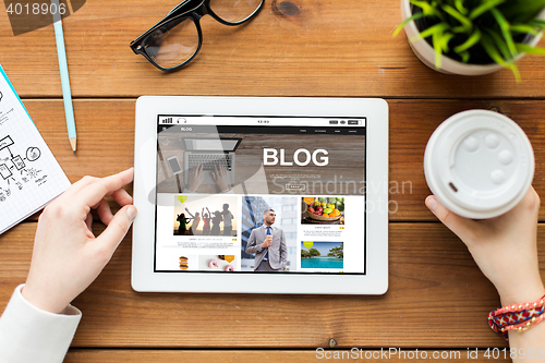 Image of close up of woman with tablet pc on wooden table