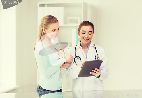 Image of happy woman with cat and doctor at vet clinic