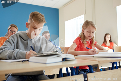 Image of group of students with books writing school test