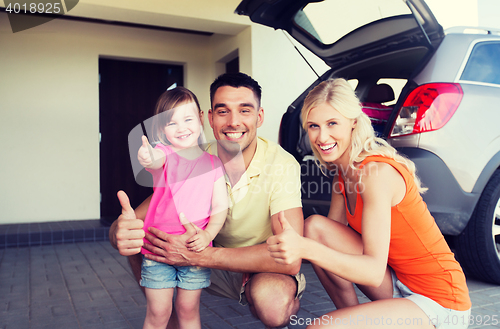 Image of happy family with car showing thumbs up at parking