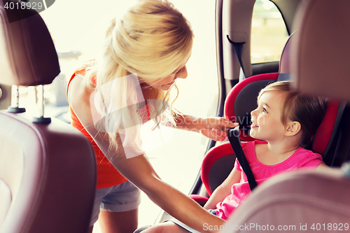 Image of happy mother fastening child with car seat belt