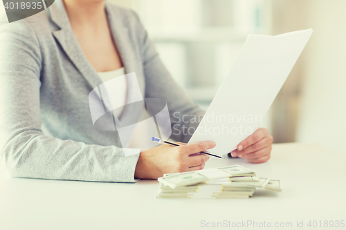 Image of close up of female hands with money and tax report