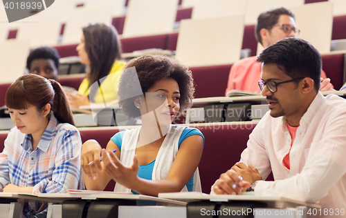 Image of group of students with notebooks in lecture hall
