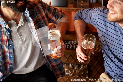 Image of happy male friends drinking beer at bar or pub