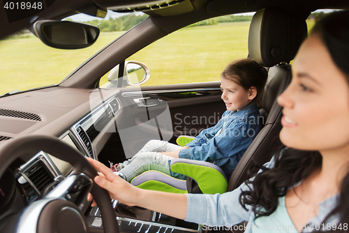 Image of happy woman with little girl driving in car