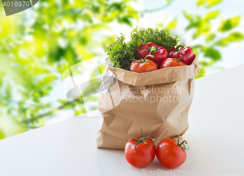 Image of paper bag with fresh ripe vegetables on table