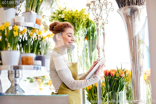 Image of woman with tablet pc computer at flower shop