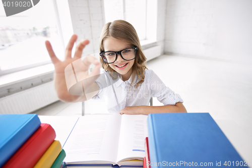 Image of happy school girl with books showing ok sign