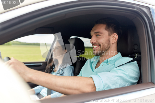 Image of happy man and woman driving in car