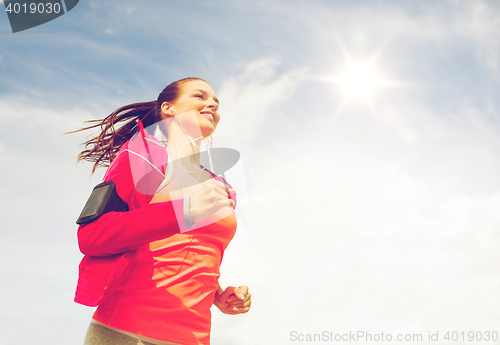 Image of smiling young woman running outdoors
