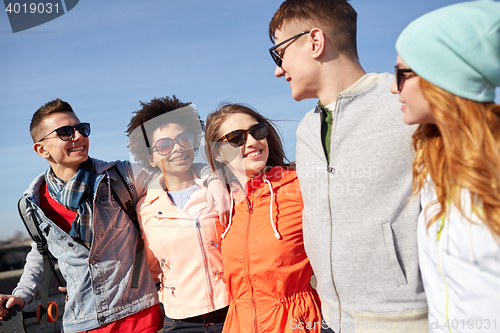 Image of smiling friends in sunglasses laughing on street