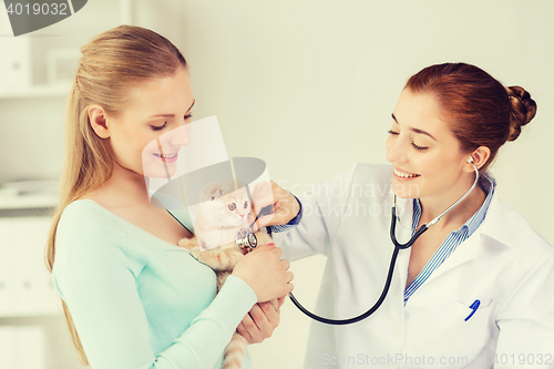 Image of happy woman with cat and doctor at vet clinic