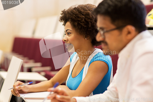 Image of group of students with notebooks in lecture hall