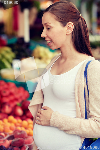 Image of pregnant woman choosing food at street market