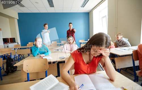 Image of students gossiping behind classmate back at school