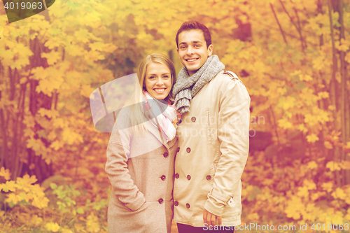 Image of smiling couple hugging in autumn park