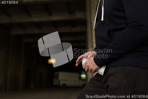 Image of close up of addict or drug dealer hands with money