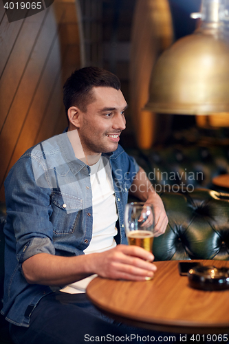 Image of happy man drinking draft beer at bar or pub