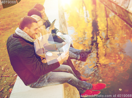 Image of couples with tourist map in autumn park