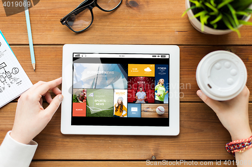 Image of close up of woman with tablet pc on wooden table