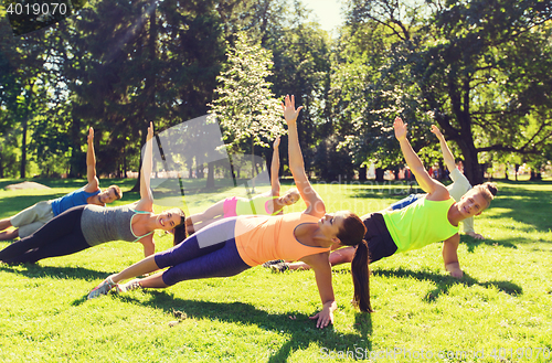 Image of group of happy friends exercising outdoors