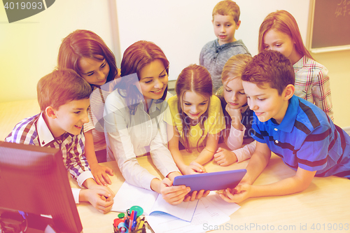 Image of group of kids with teacher and tablet pc at school