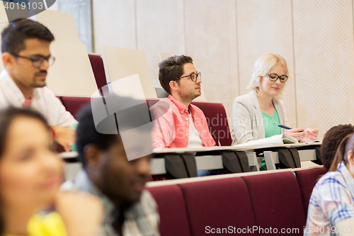 Image of group of students with notebooks in lecture hall