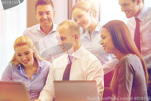 Image of smiling business people with laptop computer