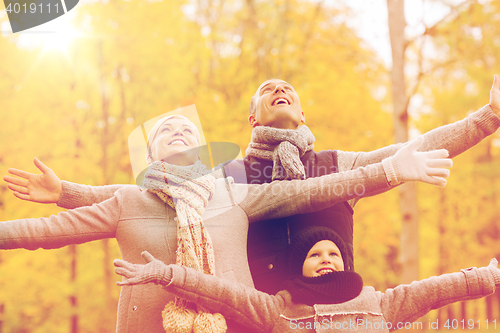 Image of happy family having fun in autumn park