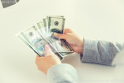 Image of close up of woman hands counting us dollar money