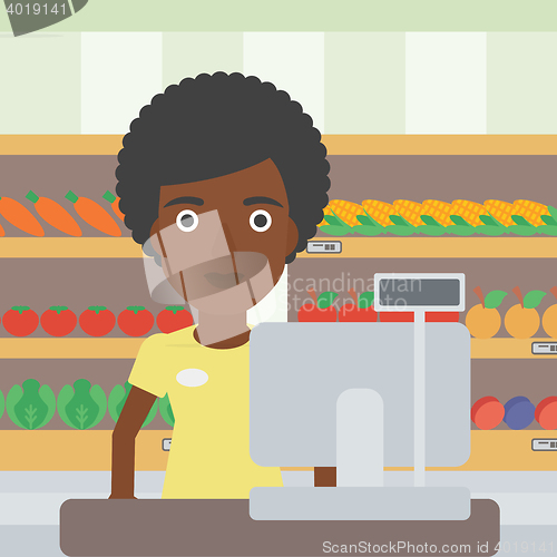 Image of Cashier standing at the checkout in supermarket.