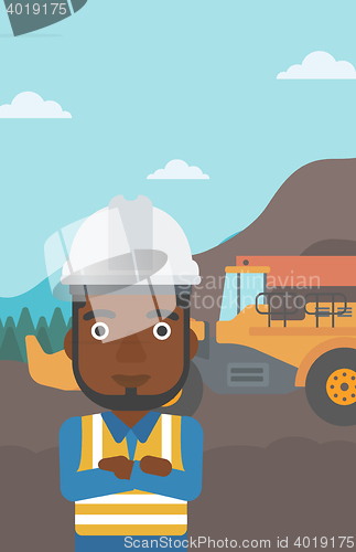 Image of Miner with mining equipment on background.