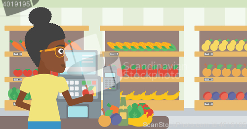 Image of Cashier standing at the checkout in supermarket.