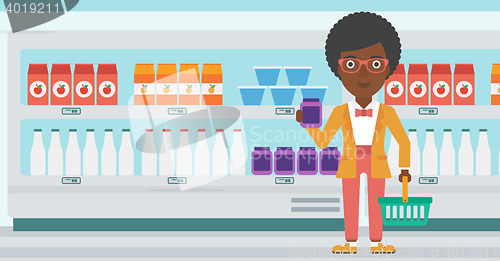 Image of Customer with shopping basket and tube of cream.