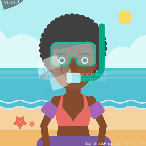 Image of Woman with snorkeling equipment on the beach.