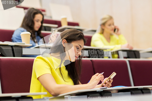 Image of student girls with smartphones on lecture