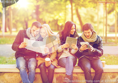 Image of couples with tourist map in autumn park