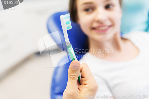Image of close up of dentist hand with toothbrush and girl