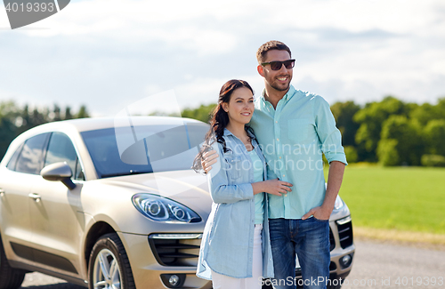 Image of happy man and woman hugging at car