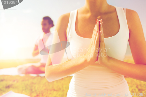 Image of close up of couple making yoga exercises outdoors